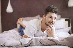 man op bed denkt aan welk matras kopen