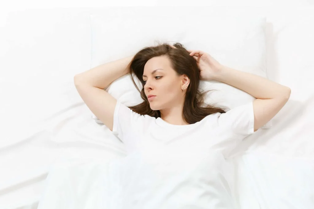 dame ligt op bed en denkt na over het beste matras voor jouw slaaphouding