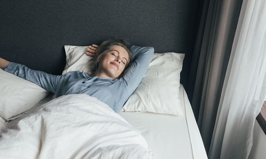 dame ligt in bed op een topdekmatras op een oud matras